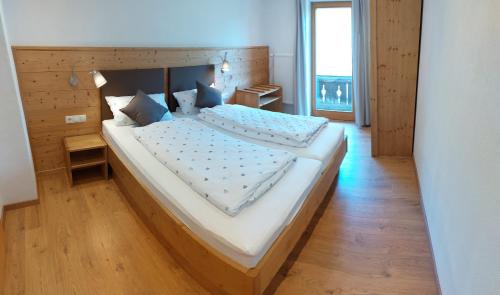 a bedroom with a large bed with a wooden headboard at Pilzhof in Schleching