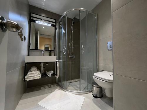 a bathroom with a shower and a toilet at Sezer's Oliva Hotel in Canakkale