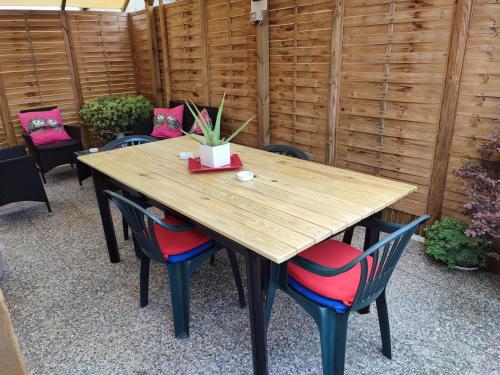 einem Holztisch mit roten Stühlen und einem Holzzaun in der Unterkunft House Viareggio in Viareggio