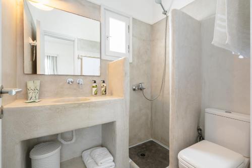 a bathroom with a sink and a toilet and a mirror at Diamantis Studios&Apartments in Mikri Vigla