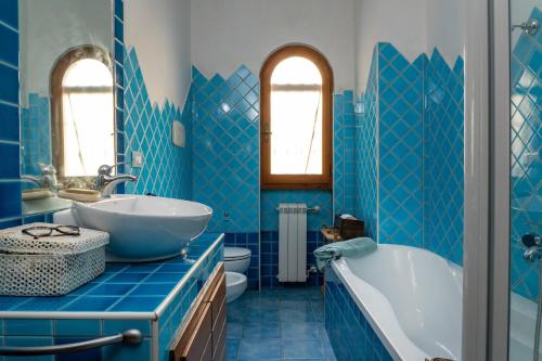a blue bathroom with a tub and a sink at Villetta sogno d'estate in Flumini di Quartu