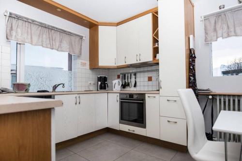 una cucina con armadi bianchi e piano cottura di *Two bathrooms* Beds for 9 pers. Great view a Grundarfjordur