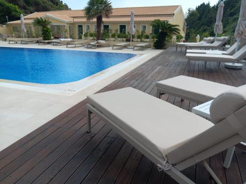 a deck with lounge chairs and a swimming pool at Corfu valley view in Paleokastritsa