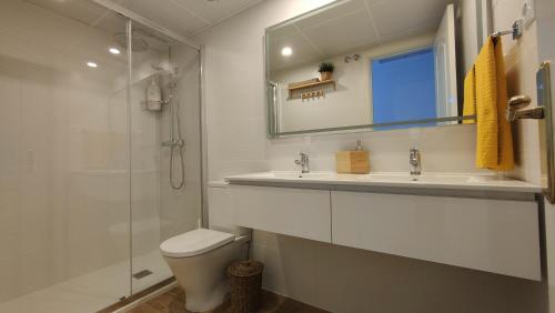y baño con aseo, lavabo y ducha. en Luxury Apartment Bajondillo Beachfront, en Torremolinos