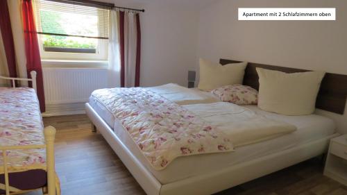 1 cama blanca en un dormitorio con ventana en Ferienwohnung Wolfsholz, en Wernigerode