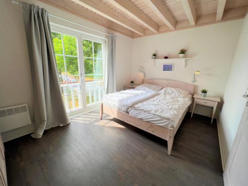 een slaapkamer met een bed en een groot raam bij Strandpark Sierksdorf H080 in Sierksdorf