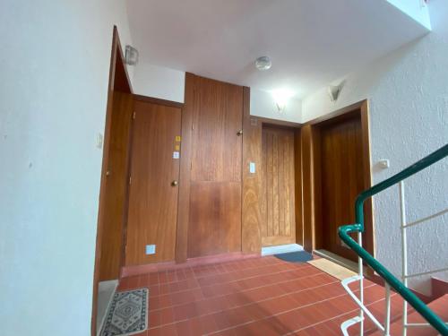 a hallway with wooden doors and a staircase at Gerês River - Apartamento na Natureza in Geres