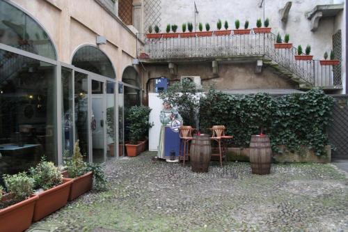 a building with a courtyard with pots of plants at P&P Borgo Apartment in Bergamo