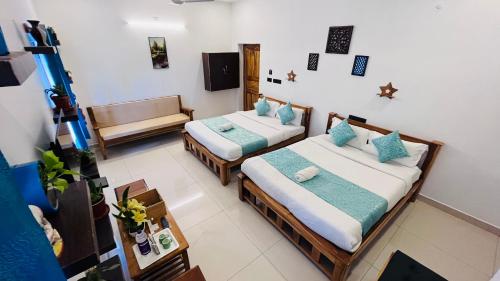 a room with two beds and a couch in it at THE LUXE HOTEL, ECR ROAD, NEAR Serenity Beach, Pondicherry - JR Groups in Puducherry