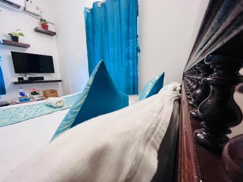a bedroom with a bed with blue pillows at THE LUXE HOTEL, ECR ROAD, NEAR Serenity Beach, Pondicherry - JR Groups in Puducherry