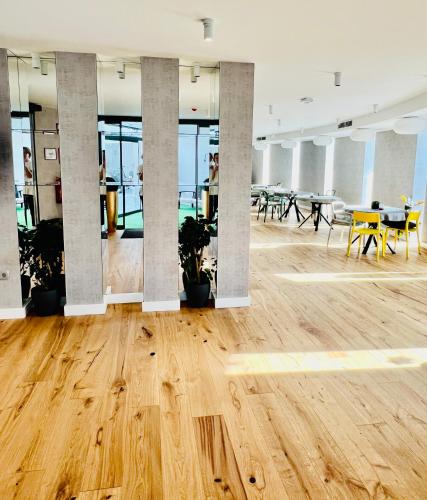 an empty office with tables and chairs and a wooden floor at TI Hotel in Rogaška Slatina