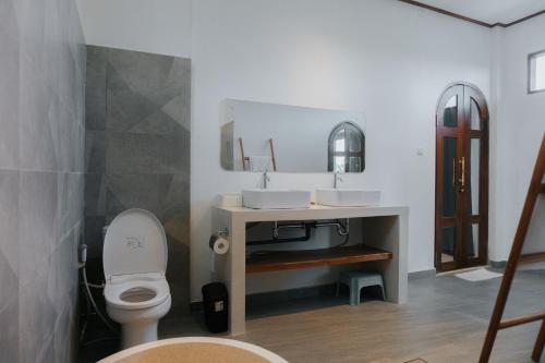 a bathroom with a toilet and a sink at Villa Gading in Ubud