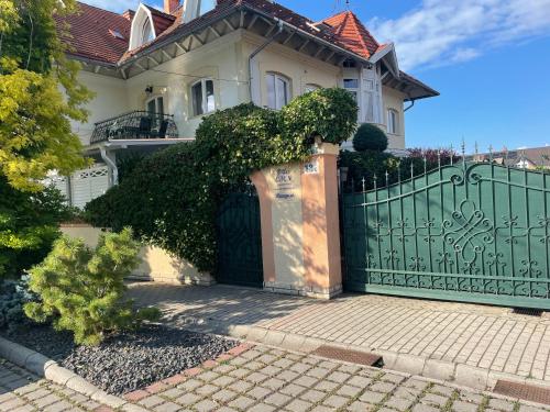 una casa con una puerta verde y una valla en Villa Éden, en Siófok