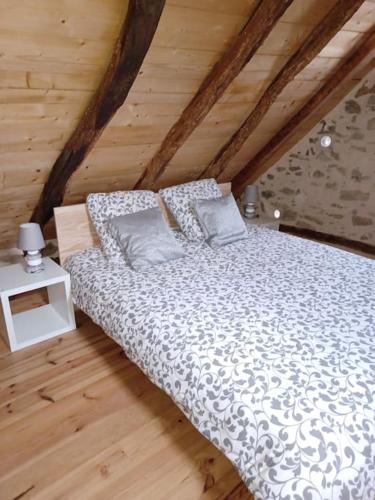 - un lit avec deux oreillers dans une chambre en bois dans l'établissement LOU PICOU, Gîte montagne habitat typique, 3 pers, à Oust