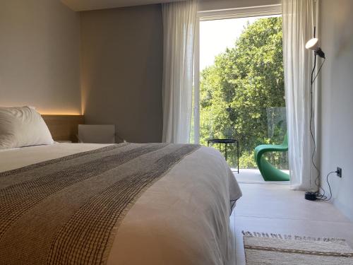 a bedroom with a bed and a large window at Hotel Farsund in Sanxenxo