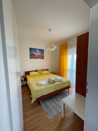 a bedroom with a yellow bed in a room at Apartmani Fulir in Vrsi