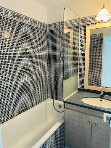 une salle de bain avec un lavabo, une baignoire et un miroir dans l'établissement Très joli Appartement 2P au Beach Résidence Trouville- Piscine & vue port, à Trouville-sur-Mer