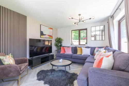 a living room with a couch and a table at Stunning Five Bed Detached Home in Golden Valley