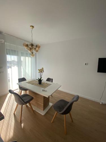 una sala da pranzo bianca con tavolo e sedie di Apartament Grand Hill 1 a Oradea