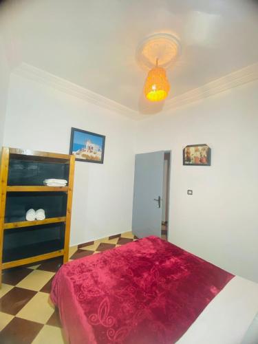 a bedroom with a bed with a red blanket at Rayane Guest House in Taghazout