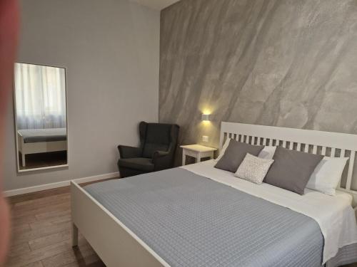 a bedroom with a large bed and a chair at City Center Apartment in Termoli