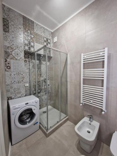 a bathroom with a washing machine and a toilet at City Center Apartment in Termoli