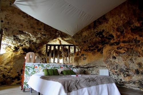 une chambre avec un lit dans un mur de pierre dans l'établissement La suite des fouleries, à Châteaudun