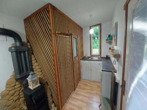 a room with a staircase leading to a kitchen with a stove at Retreat în padure in Buchin