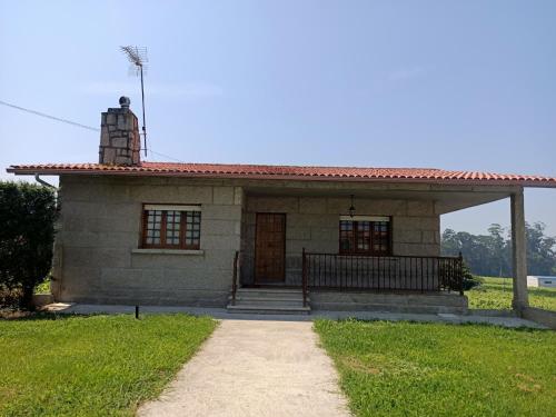 a small stone house with a red roof at Lar a de Luis in Ribadumia