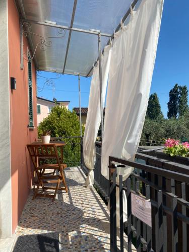 patio con tenda da sole, tavolo e sedia di La casetta di Andreina a Sarzana