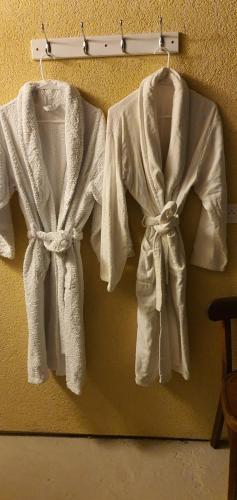 three white towels are hanging on a wall at La suite des fouleries in Châteaudun