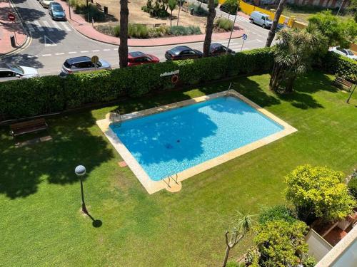 eine Aussicht auf einen Pool im Gras in der Unterkunft Nice new flat near the beach in Lloret de Mar