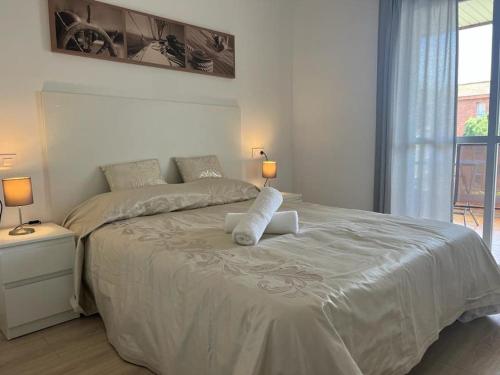 ein weißes Schlafzimmer mit einem großen Bett mit zwei Kissen in der Unterkunft Nice new flat near the beach in Lloret de Mar