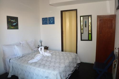 a bedroom with a bed with a towel on it at Pousada Mare Blue in Búzios