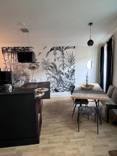 a living room with a table and a kitchen at Appartement de caractère in Épinal