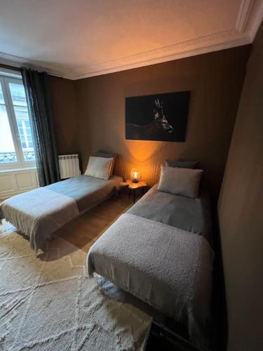 Un pat sau paturi într-o cameră la Appartement de caractère