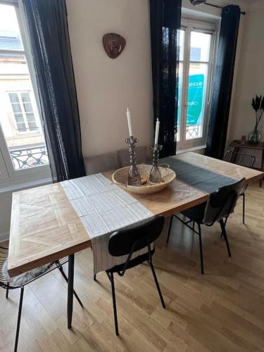 a wooden table with two candles on top of it at Appartement de caractère in Épinal