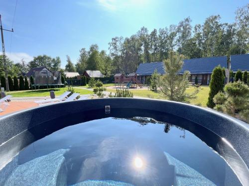 a plunge pool with a view of a yard at Domki Zalesie in Jarosławiec
