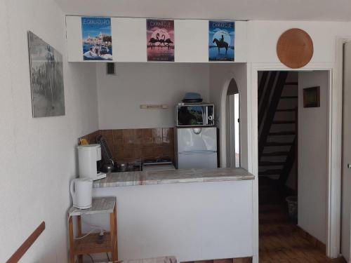 - une cuisine avec un comptoir et un réfrigérateur dans l'établissement Le Frioul, au Grau-du-Roi