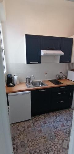 une cuisine avec un évier et un plan de travail dans l'établissement Appartement hyper centre à 250 m de la plage, à Arcachon