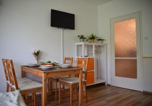 a dining room with a wooden table and chairs at Helikon 32 Apartman Keszthely in Keszthely