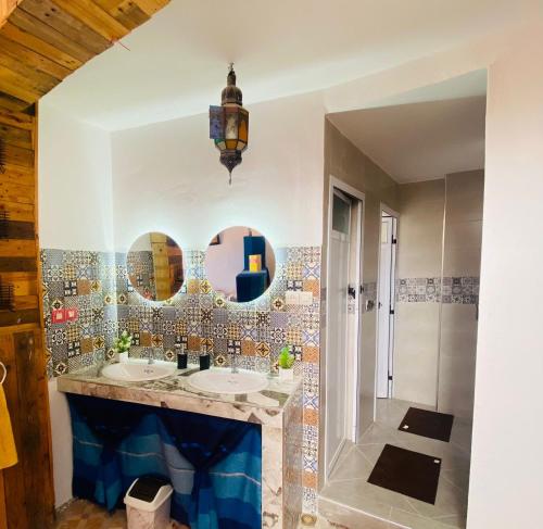 un bagno con due lavandini e due specchi di Rayane Guest House a Taghazout