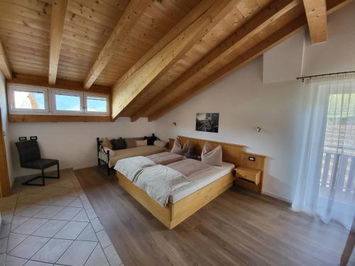 a bedroom with a large bed in a room with wooden ceilings at Panorama Residence Rebgut in Schenna