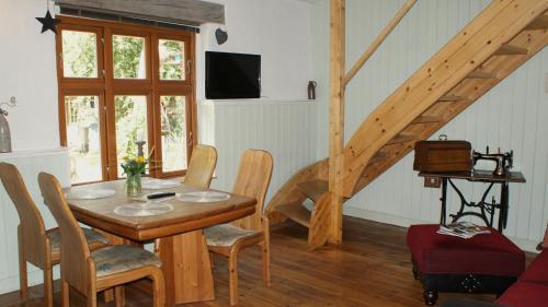 uma sala de jantar com uma mesa e cadeiras e uma escadaria em Ferienwohnung Fuchsberge em Letschin