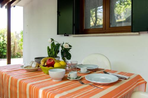 a table with a bowl of fruit and plates on it at La Conchiglia in Chioggia
