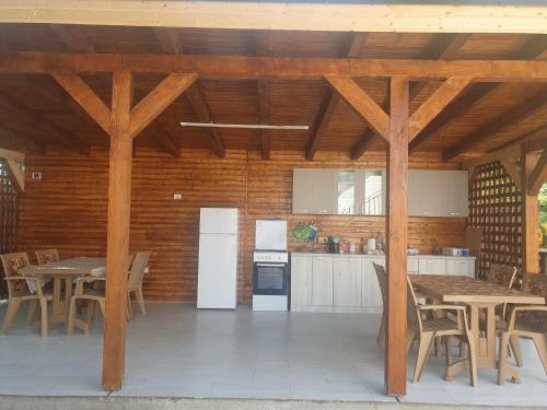 cocina con techos de madera, mesa y sillas en CAZARE EDI, en Corbu