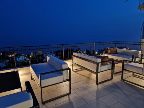 a group of chairs and tables on a balcony at night at Adriatic Apartments in Ulcinj