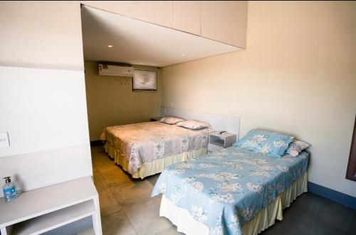 Cette petite chambre comprend deux lits et une table. dans l'établissement Horizonte Azul Noronha, à Fernando de Noronha