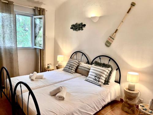 - 2 lits dans une chambre avec une guitare sur le mur dans l'établissement Maison Pinarellu plage à pieds, à Zonza