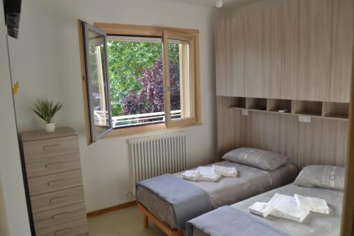 ジュリアノーヴァにあるIl Terrazzo 40 metri dal mareのベッドルーム1室(ベッド2台、窓付)